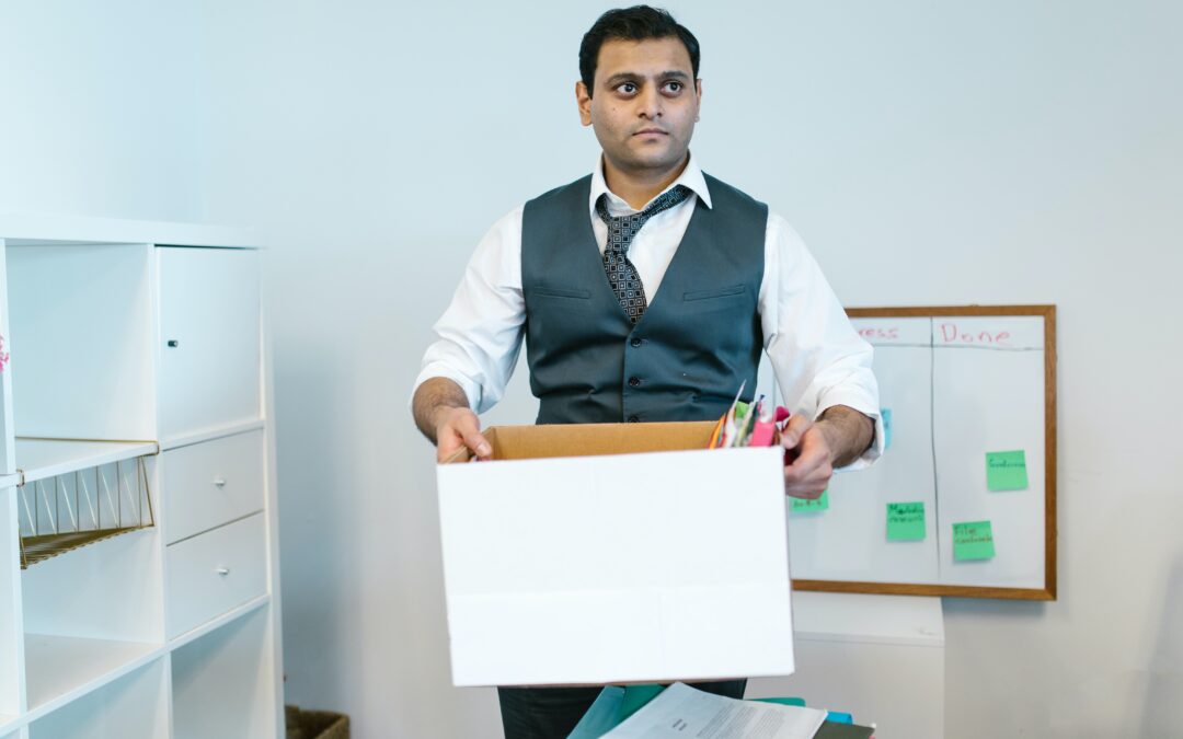 An office worker carrying a box they packed of their belongings